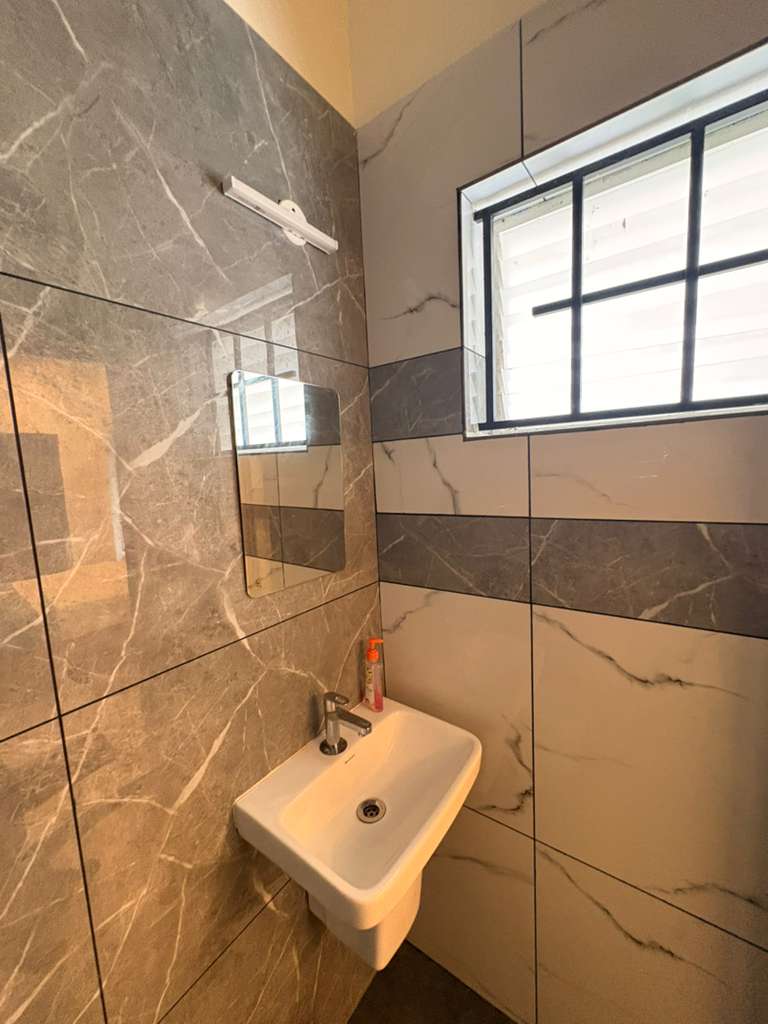Ensuite bathroom with marble-tiled walls